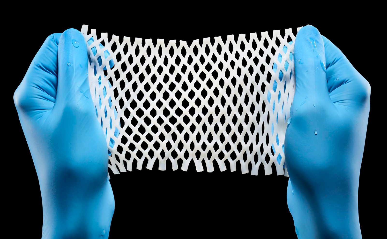 medical product photography of white medical mesh on black background