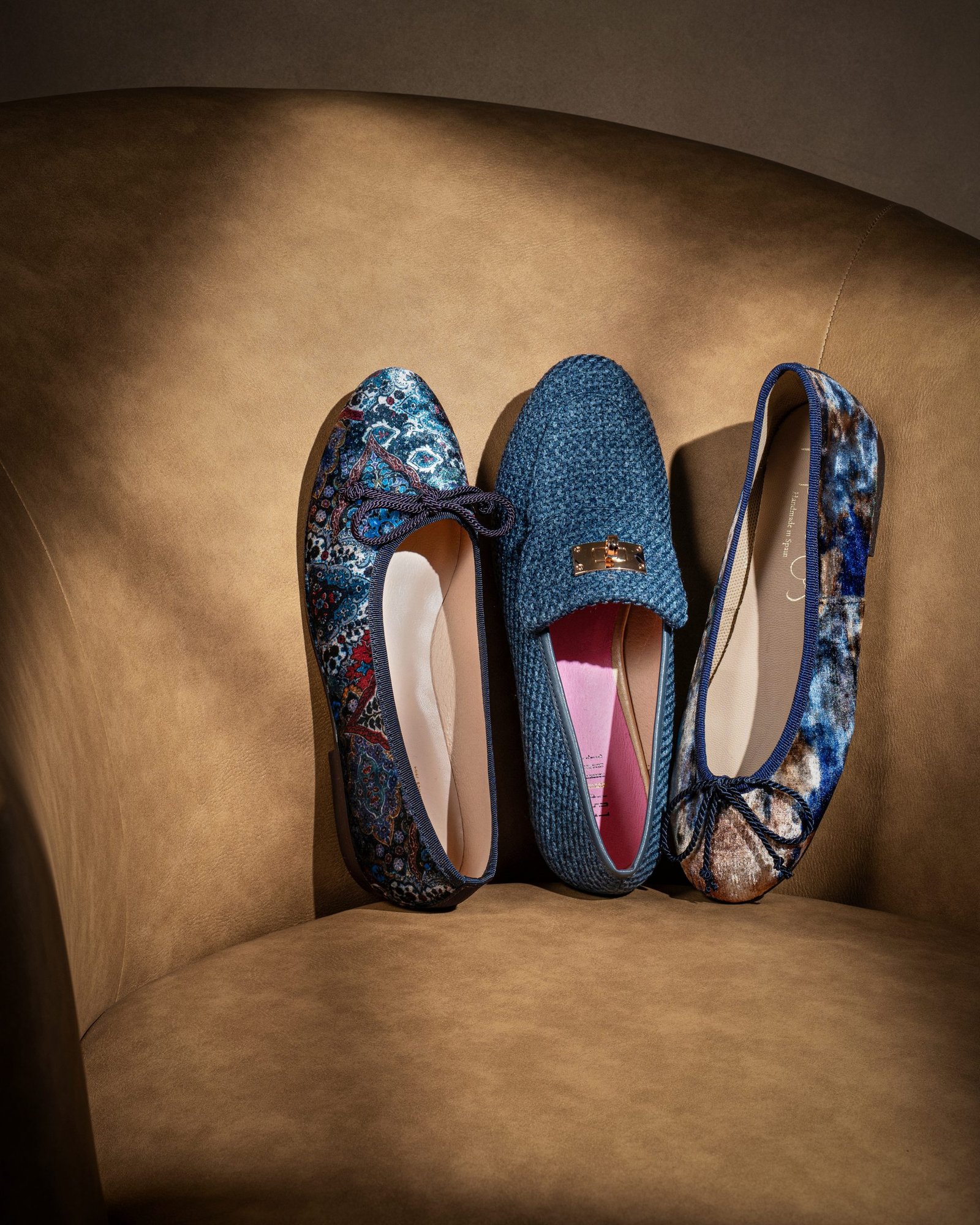 product lifestyle photography of blue and floral patterned women's shoes on tan chair with shadows