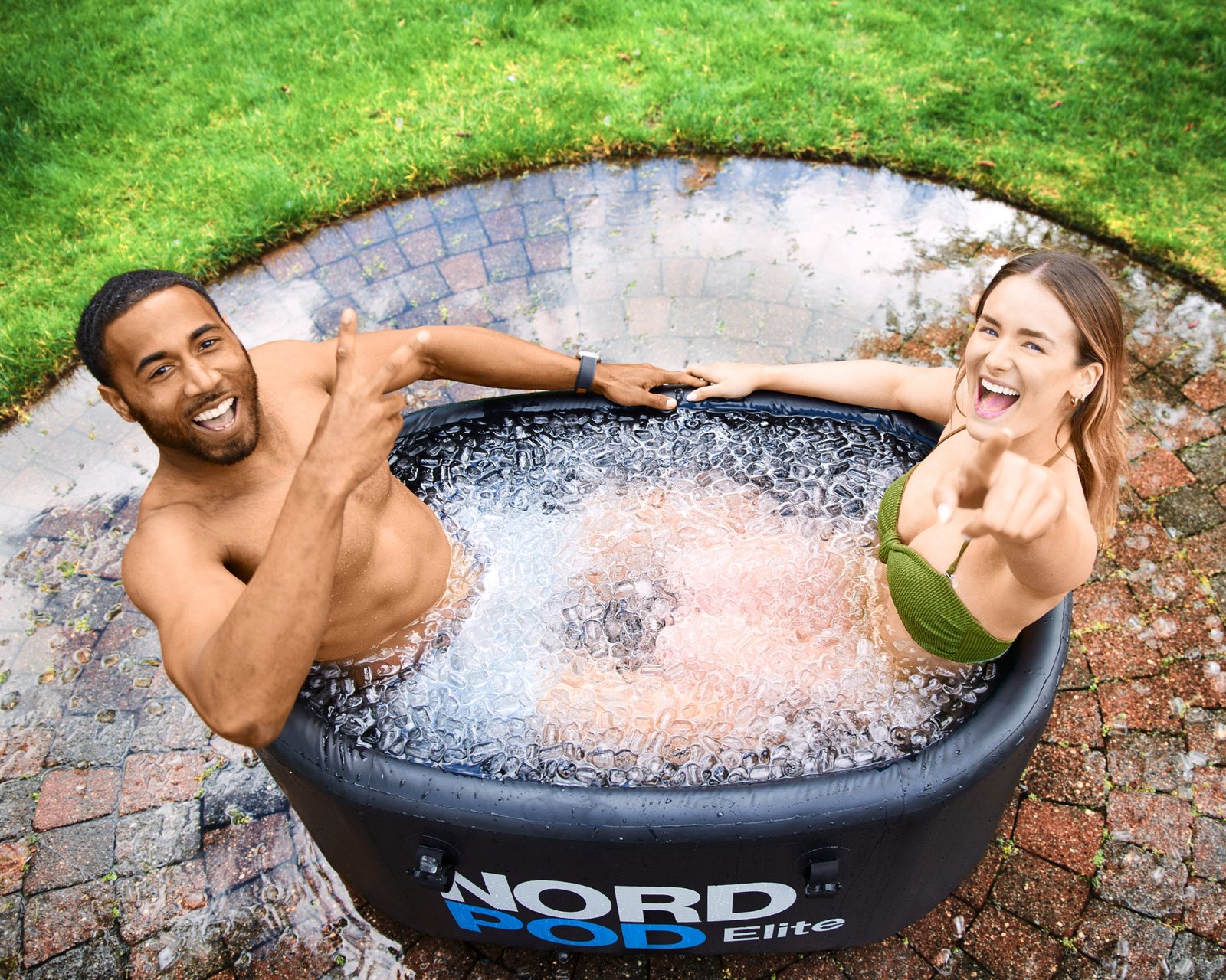 product lifestyle photography of ice tub outside on patio and grass with models in ice tub climbing out of ice tub