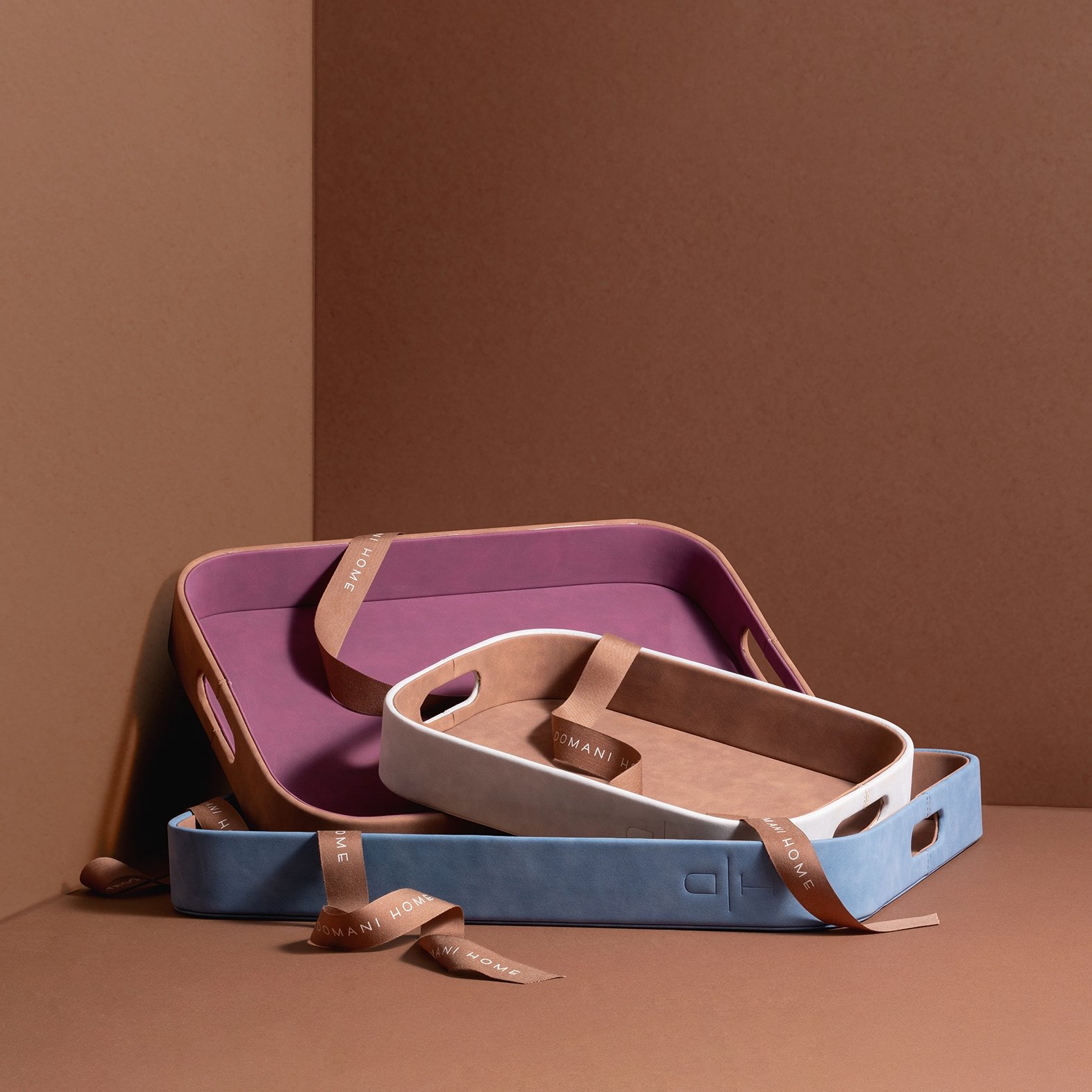 product lifestyle photography of multi colored trays stacked on brown background in corner wall tabletop scene