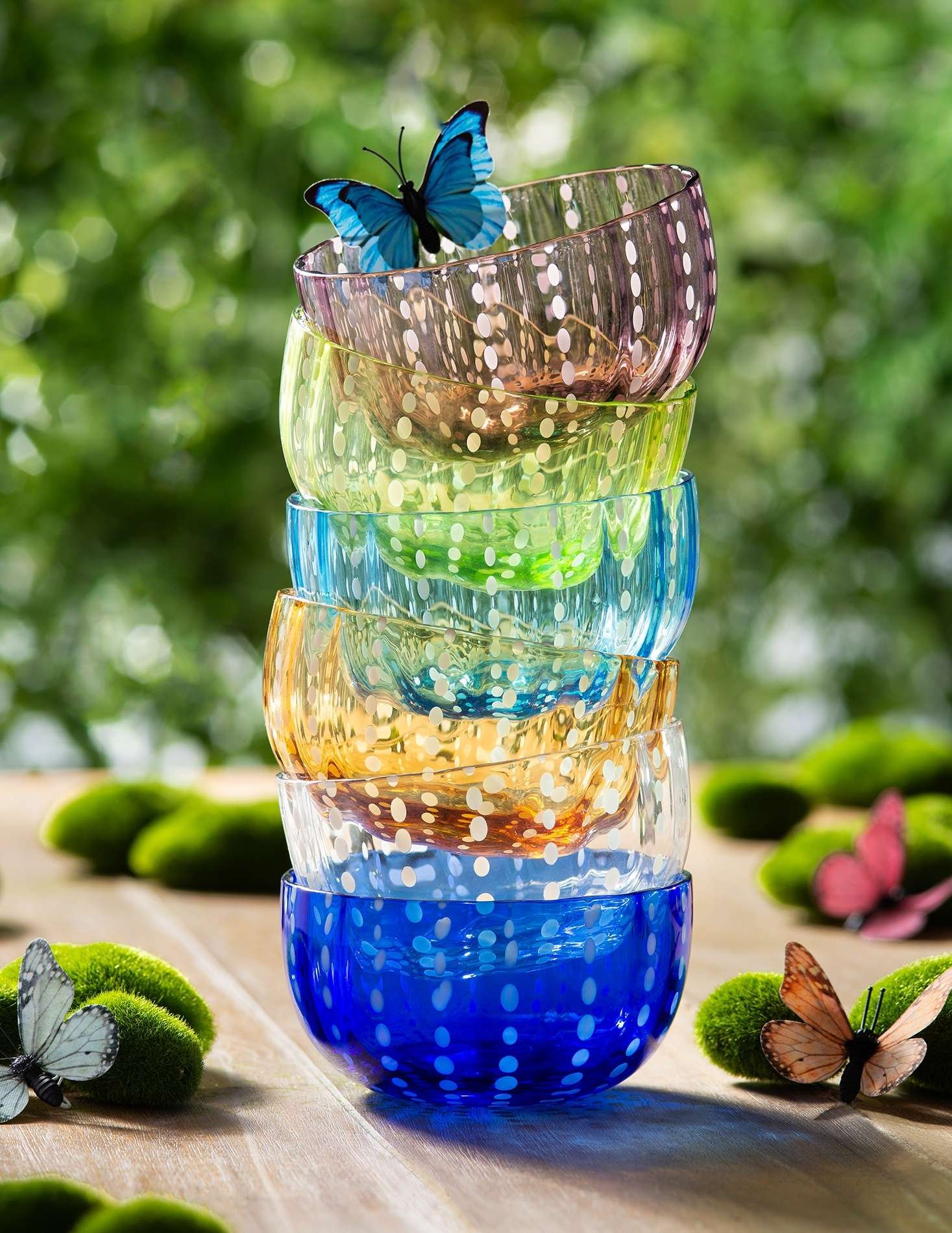 product lifestyle photography of colored acrylic bowls stacked in backyard picnic table scene